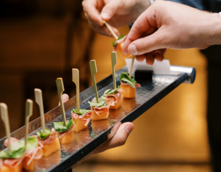 Cocktail hour photo, passed appetizers on a tray of prosciutto and melon